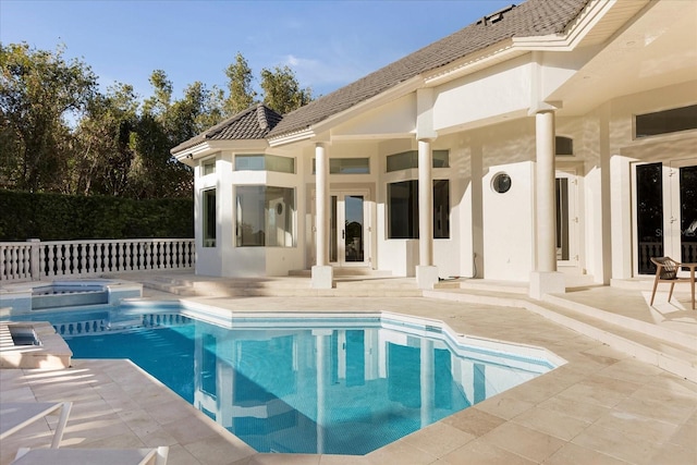 view of swimming pool featuring a patio area, a pool with connected hot tub, and fence