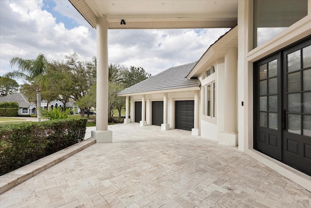 view of patio with decorative driveway and a garage