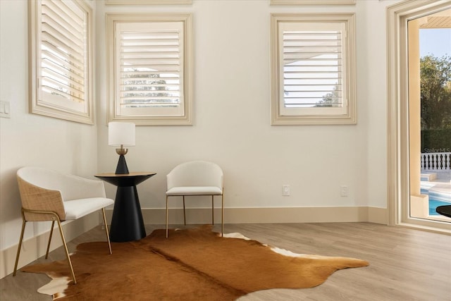 living area with baseboards and wood finished floors