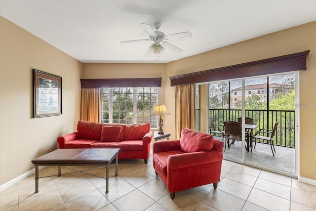 living room featuring ceiling fan, light tile patterned floors, and baseboards