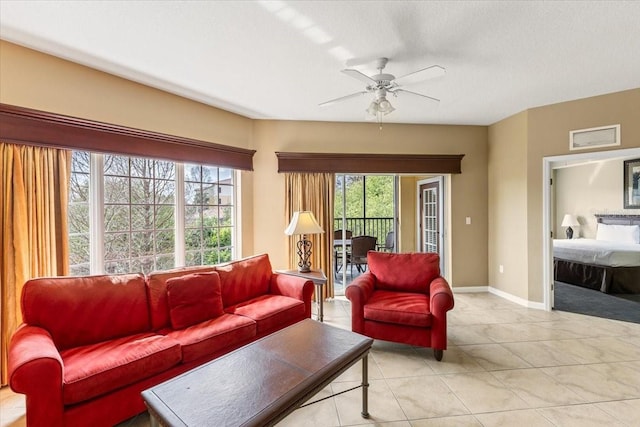 living room featuring ceiling fan, light tile patterned flooring, and baseboards