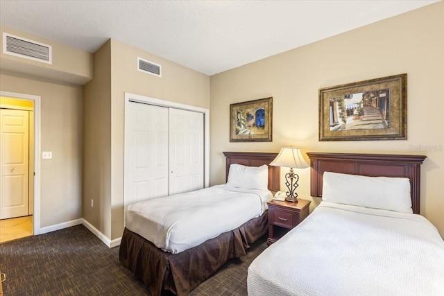 carpeted bedroom with a closet, visible vents, and baseboards