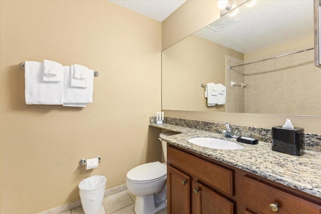 bathroom featuring a shower, toilet, vanity, tile patterned flooring, and baseboards