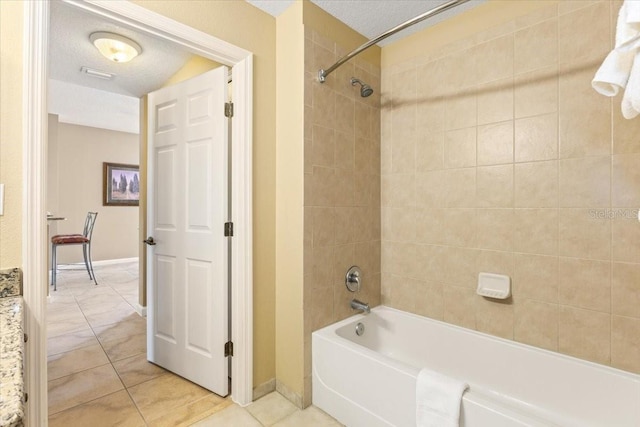 full bathroom with visible vents, tub / shower combination, a textured ceiling, baseboards, and tile patterned floors