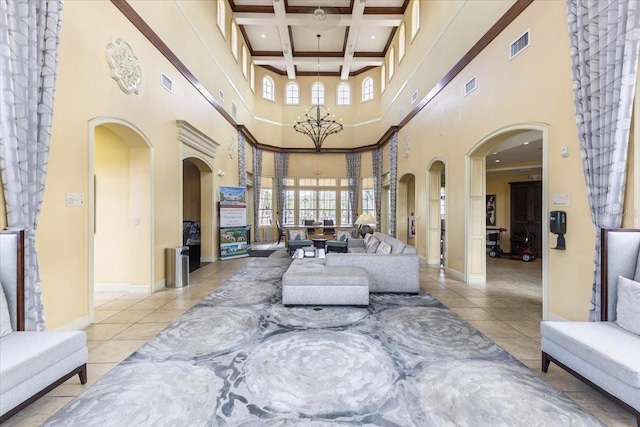 living room with arched walkways, light tile patterned floors, coffered ceiling, visible vents, and beamed ceiling