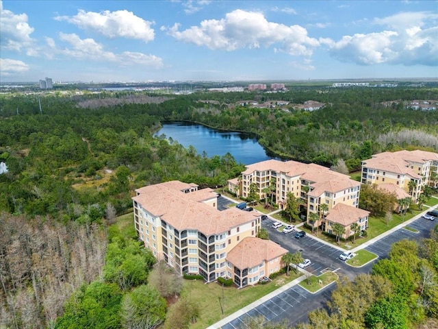 drone / aerial view with a water view and a view of trees