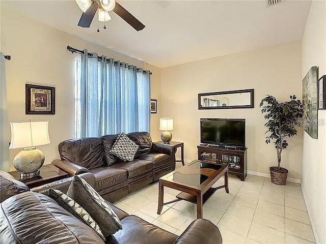 living area with light tile patterned flooring, ceiling fan, and baseboards