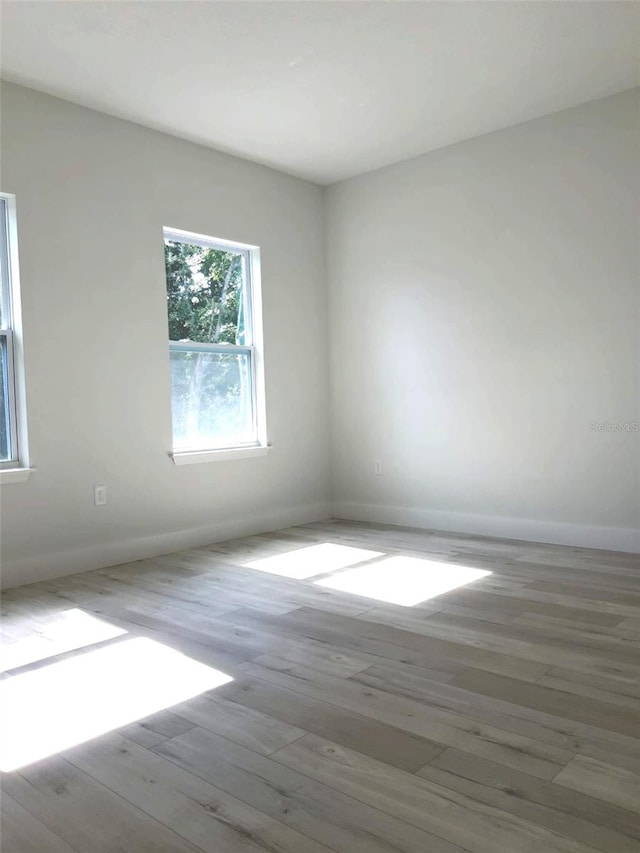 empty room featuring wood finished floors and baseboards