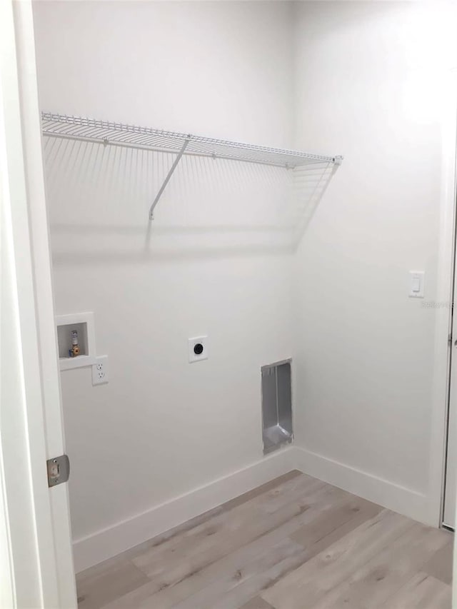 washroom featuring laundry area, electric dryer hookup, washer hookup, light wood finished floors, and baseboards