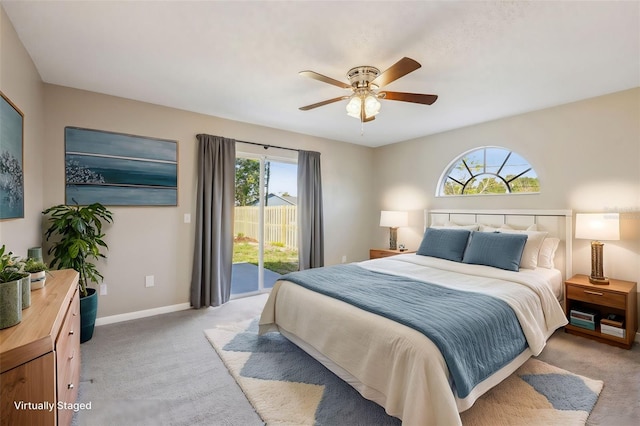 bedroom with a ceiling fan, access to exterior, light colored carpet, and baseboards