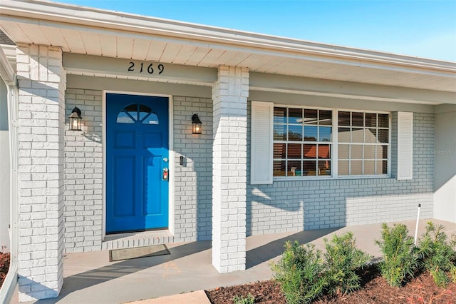 view of exterior entry with brick siding