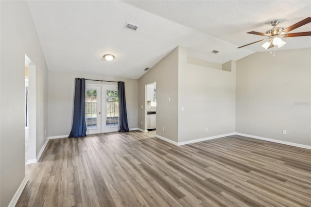 unfurnished room featuring visible vents, baseboards, vaulted ceiling, french doors, and wood finished floors