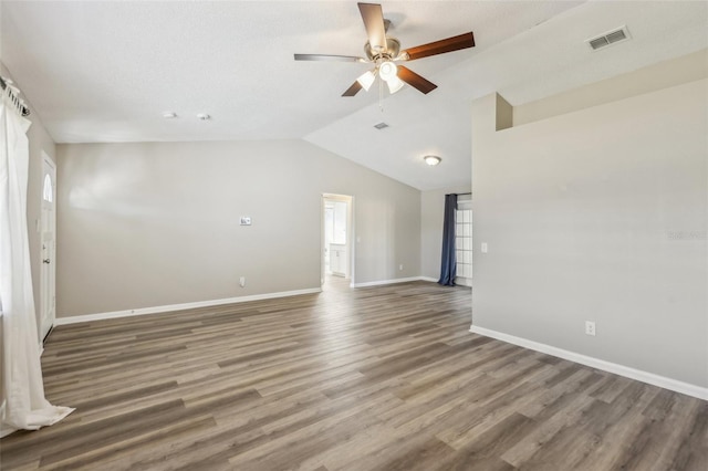 interior space with visible vents, baseboards, lofted ceiling, and wood finished floors