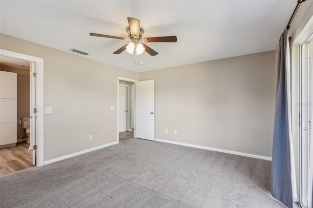 unfurnished bedroom with visible vents, baseboards, carpet floors, a textured ceiling, and a ceiling fan