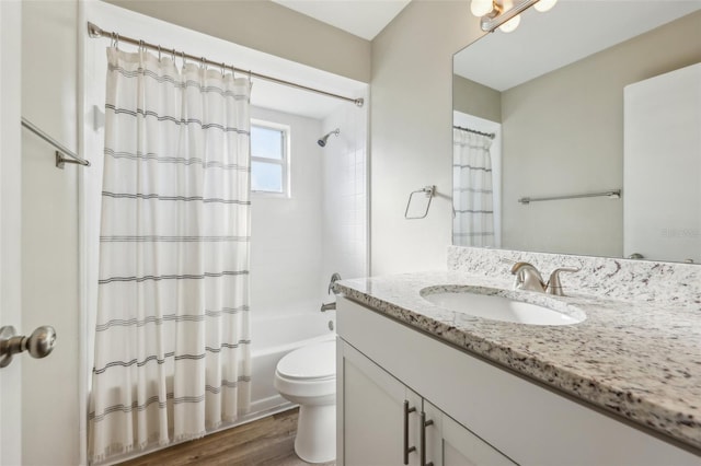 bathroom featuring wood finished floors, toilet, vanity, and shower / bath combo