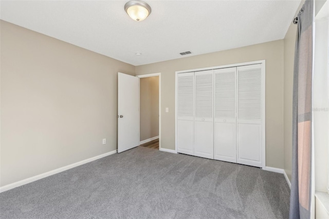 unfurnished bedroom featuring visible vents, baseboards, a closet, and carpet flooring