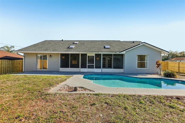 rear view of house featuring a fenced in pool, a sunroom, a yard, a fenced backyard, and a patio area