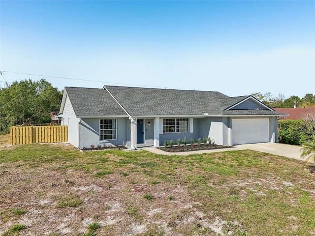 ranch-style house featuring a front yard, fence, roof with shingles, an attached garage, and concrete driveway