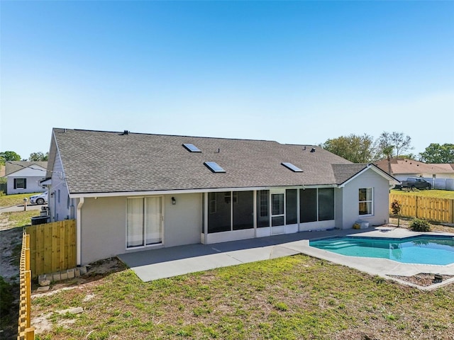 rear view of house with a sunroom, fence, a shingled roof, a fenced in pool, and a patio area