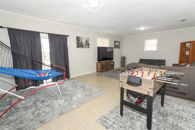 game room featuring tile patterned flooring, visible vents, a textured ceiling, and baseboards