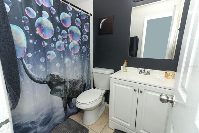 bathroom featuring a shower with curtain, vanity, toilet, and tile patterned floors