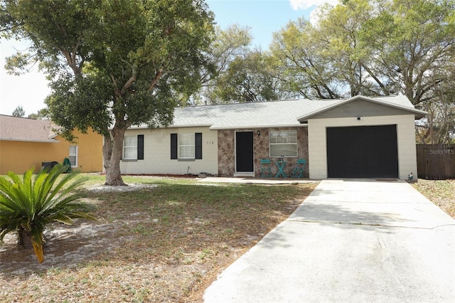 single story home featuring a garage, a shingled roof, concrete block siding, fence, and driveway