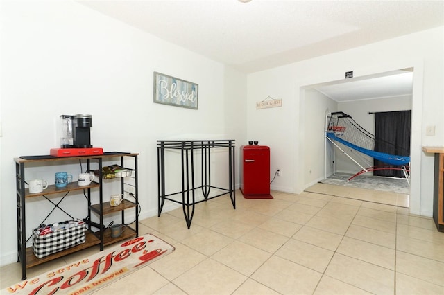 hallway featuring tile patterned flooring and baseboards