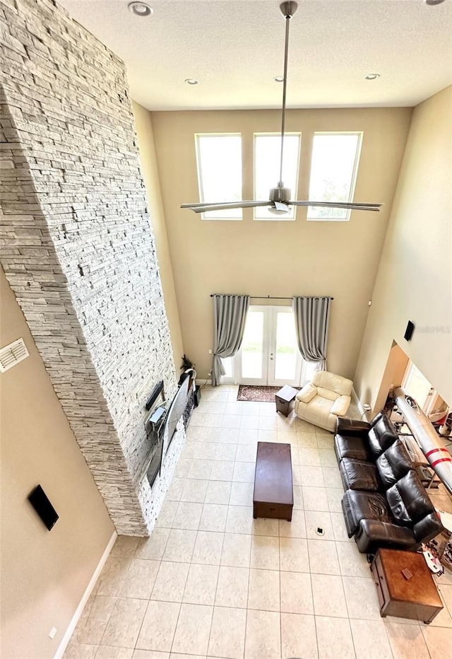 living room featuring light tile patterned floors, french doors, visible vents, and a textured ceiling