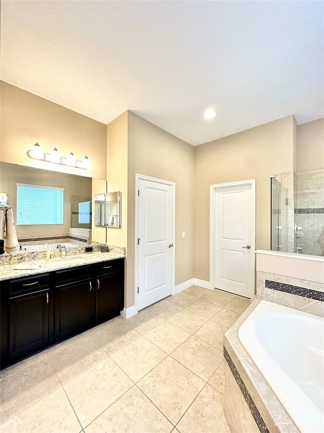 bathroom with tile patterned floors, a garden tub, a tile shower, baseboards, and vanity