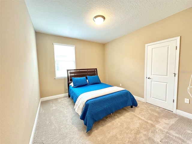 carpeted bedroom with baseboards and a textured ceiling