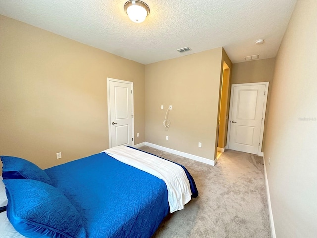 carpeted bedroom with visible vents, baseboards, and a textured ceiling