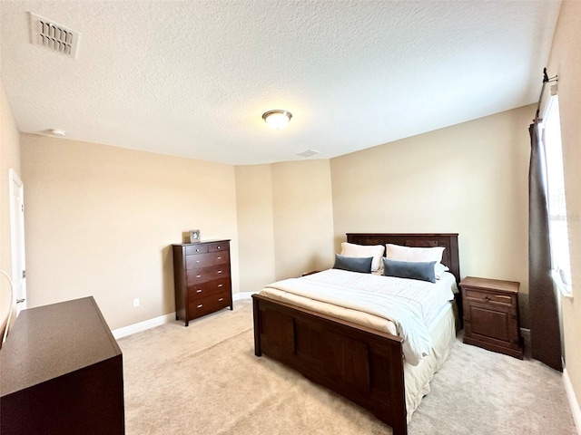 bedroom with baseboards, visible vents, a textured ceiling, light carpet, and multiple windows