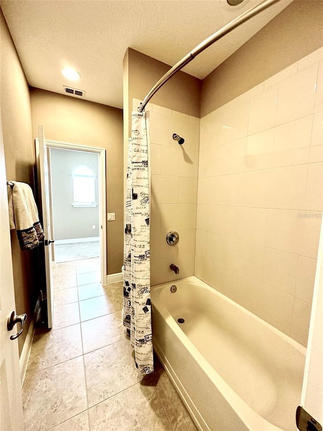 bathroom with shower / bathtub combination with curtain, baseboards, visible vents, tile patterned flooring, and a textured ceiling