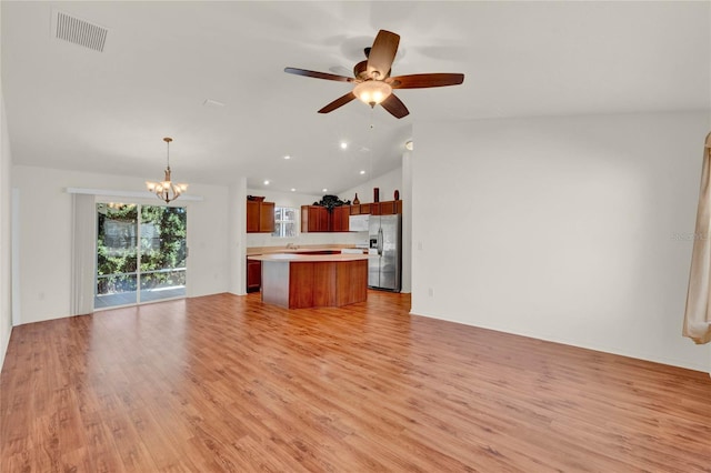 unfurnished living room featuring visible vents, lofted ceiling, ceiling fan with notable chandelier, light wood-style floors, and recessed lighting