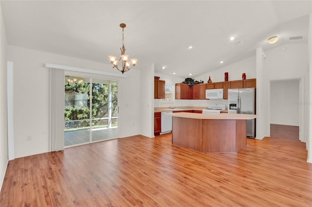 kitchen with light wood-type flooring, white appliances, light countertops, and a center island