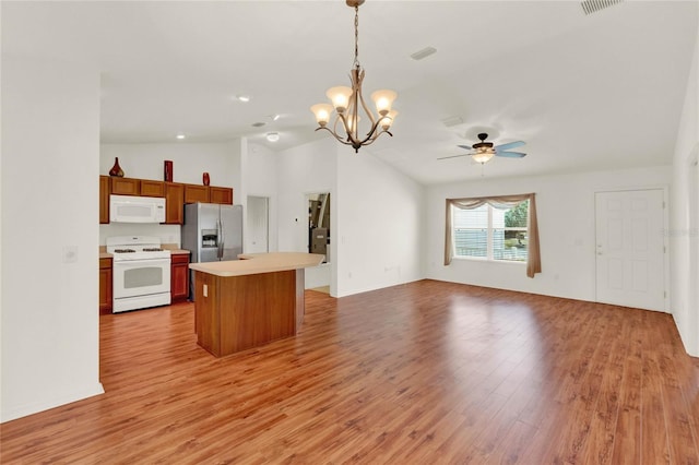 kitchen featuring open floor plan, light countertops, white appliances, and light wood-style floors