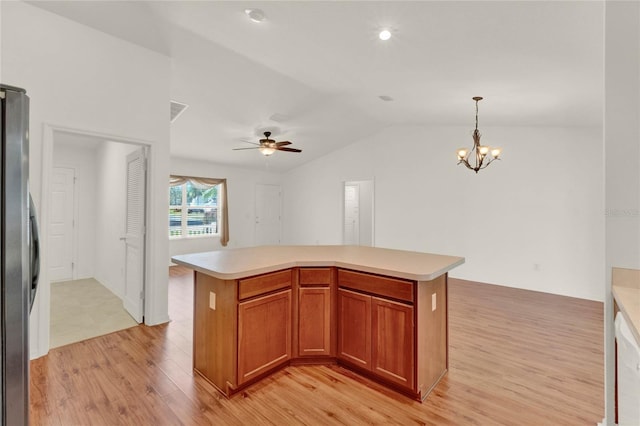 kitchen featuring lofted ceiling, light wood-style flooring, freestanding refrigerator, light countertops, and pendant lighting