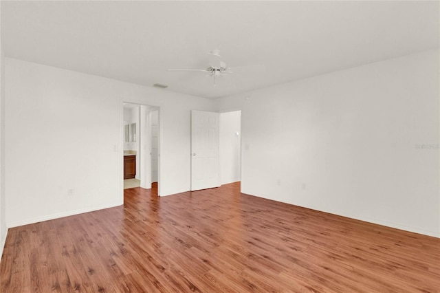 unfurnished bedroom featuring ceiling fan, connected bathroom, light wood-style flooring, visible vents, and baseboards