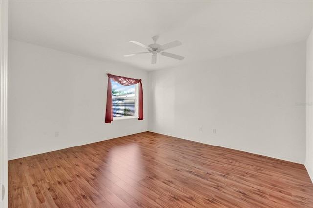 unfurnished room featuring baseboards, a ceiling fan, and wood finished floors