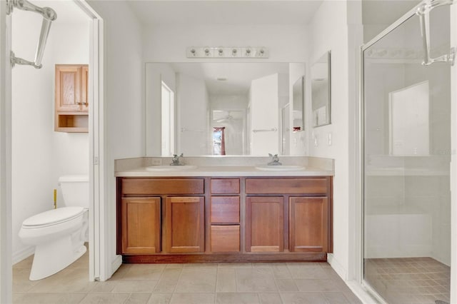 full bath with a stall shower, a sink, toilet, and double vanity