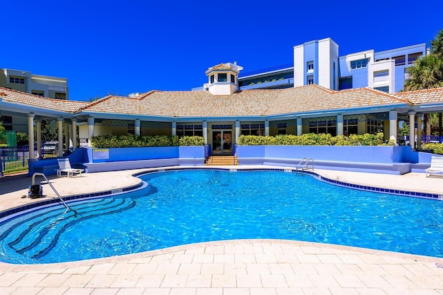 pool with french doors and a patio area