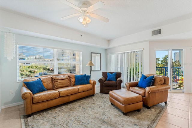 living area featuring ceiling fan, light tile patterned flooring, visible vents, and baseboards