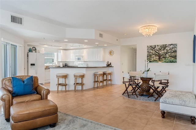 living area featuring light tile patterned floors, visible vents, a chandelier, and recessed lighting