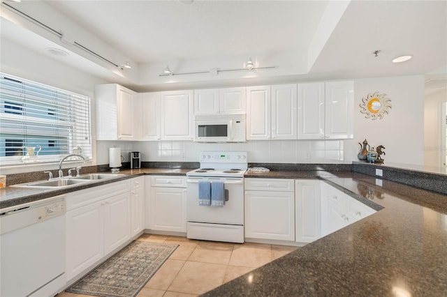 kitchen with white appliances, white cabinets, a sink, and light tile patterned floors