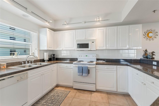 kitchen featuring white appliances, white cabinetry, decorative backsplash, and a sink