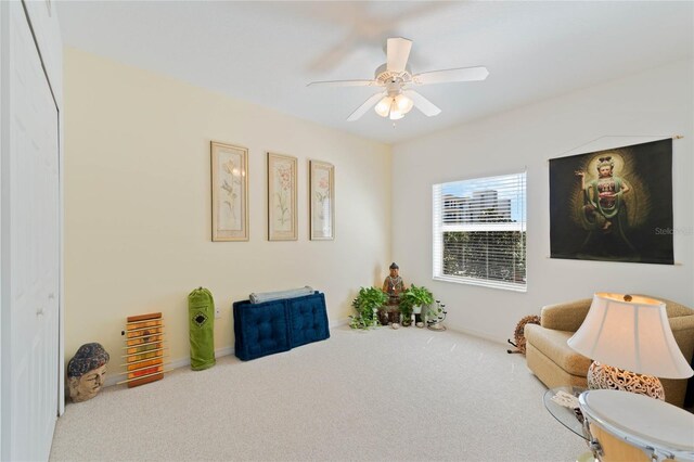 living area with carpet floors and ceiling fan