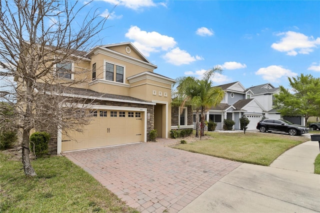 view of front of home with stucco siding, a front lawn, decorative driveway, stone siding, and a garage