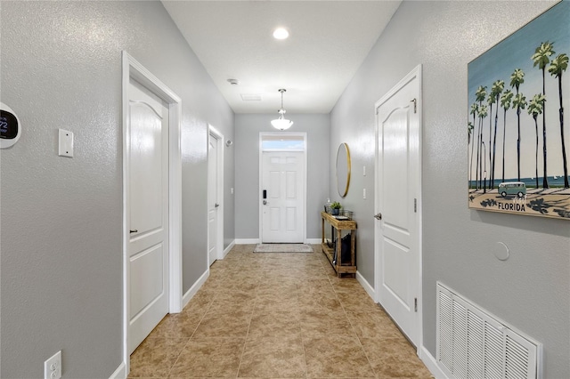 interior space featuring light tile patterned floors, visible vents, and baseboards