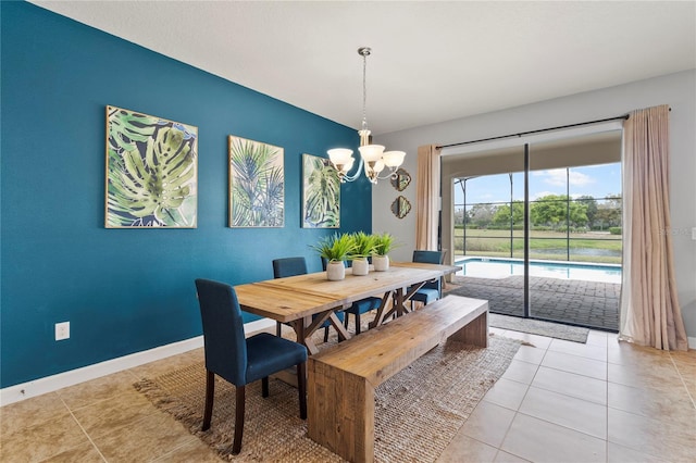 dining area featuring light tile patterned floors, baseboards, and a chandelier