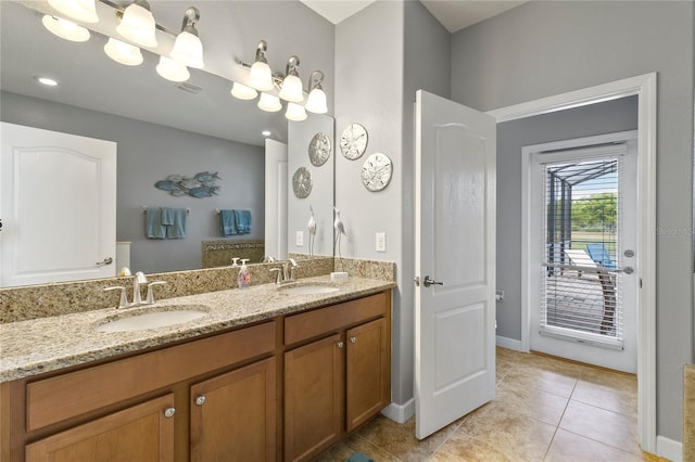 bathroom featuring tile patterned flooring, double vanity, baseboards, and a sink